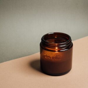 Déodorant naturel — pot ambré sur fond nude